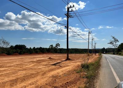 Vacant land plot beside a road under a clear blue sky