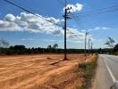 Vacant land plot beside a road under a clear blue sky