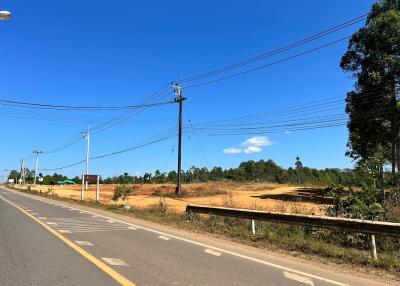 Empty plot of land adjacent to a road under clear blue sky