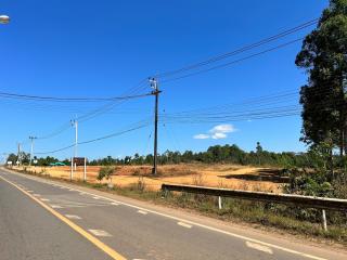 Empty plot of land adjacent to a road under clear blue sky