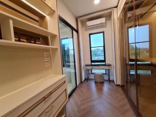 Cozy bedroom with built-in shelves and storage, large windows with a view, and hardwood flooring