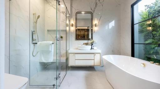 Modern bathroom with marble tiles, glass shower, elegant bathtub, and vanity sink
