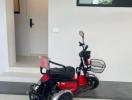 Electric scooter parked at the entrance of a modern home with white walls and a door in the background