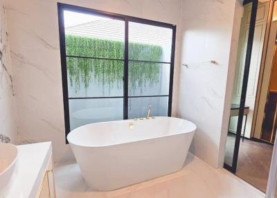 Modern bathroom with freestanding bathtub and marble walls
