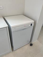 Compact laundry area with a white, front-loading washing machine