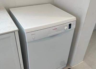 Compact laundry area with a white, front-loading washing machine