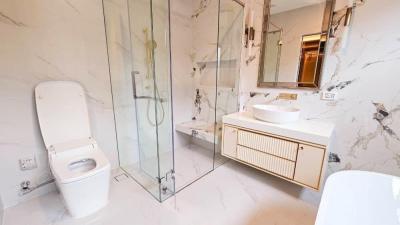 Modern bathroom with marble walls, glass shower and stylish fixtures
