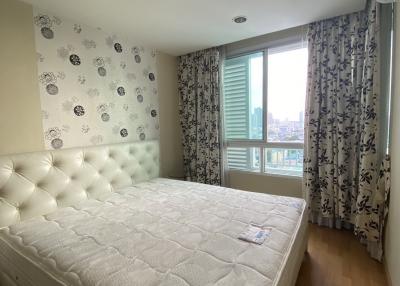 Modern bedroom with city view and patterned wallpaper