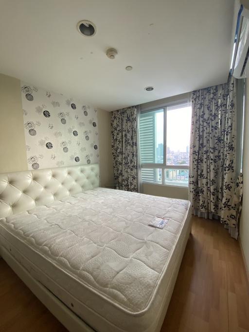 Modern bedroom with city view and patterned wallpaper