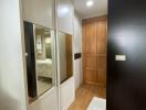 Hallway interior with mirror sliding door and wooden entrance door