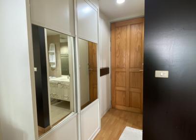 Hallway interior with mirror sliding door and wooden entrance door