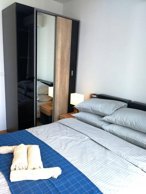 Modern bedroom with a blue comforter and wooden furnishings