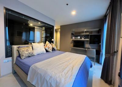 Modern bedroom with large bed and in-built shelving