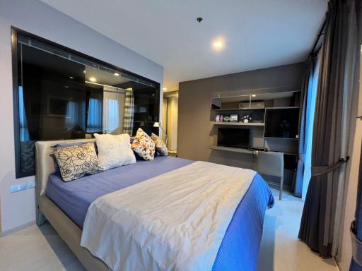 Modern bedroom with large bed and in-built shelving