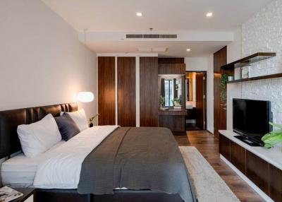 Modern bedroom interior with king-sized bed, TV, and hardwood finishing