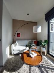 Modern living room with natural lighting, comfortable white sofa, and wooden table