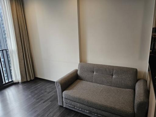 Minimalist living room with a modern grey sofa and ample natural light