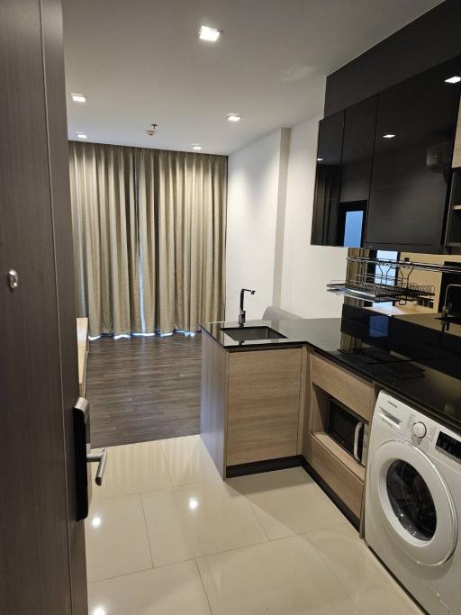 Modern kitchen with stainless steel appliances and white tiling