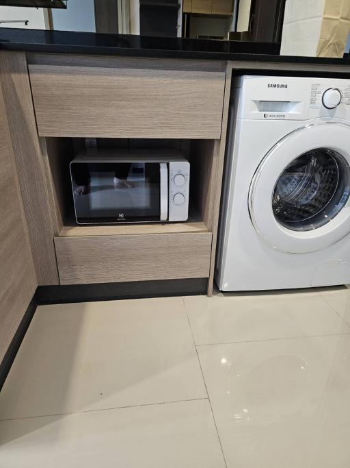 Modern kitchen with built-in appliances including a microwave and washing machine