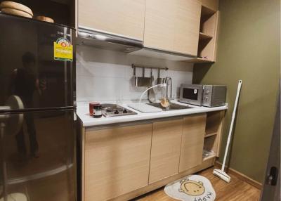 Modern compact kitchen with stainless steel appliances and wooden cabinets