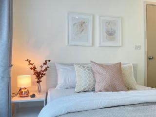 Cozy bedroom with neatly arranged bed, decorative pillows, and wall art