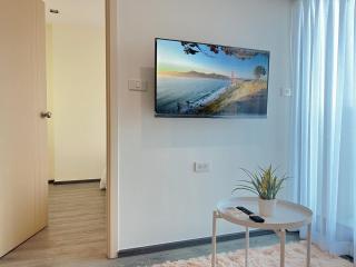 Modern living room with wall-mounted TV and minimalistic furniture