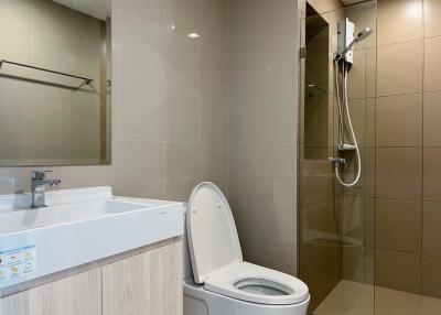 Modern bathroom with beige tiles and white fixtures