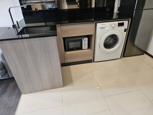 Modern kitchen with built-in appliances and glossy floor tiles