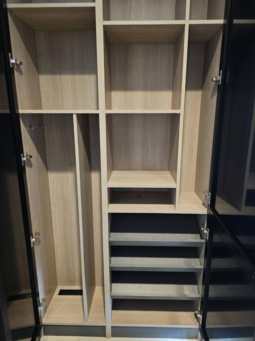 Modern wooden closet with open doors revealing shelves and drawers