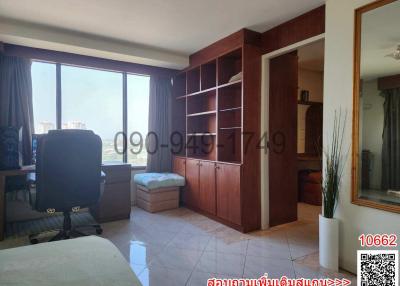 Spacious living room with large windows and wooden bookshelf