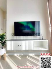 Bright and modern living room with mounted television and white storage furniture