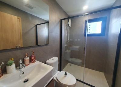 Modern bathroom with glass shower and wooden cabinets