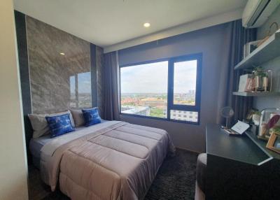 Spacious bedroom with a large window offering a city view