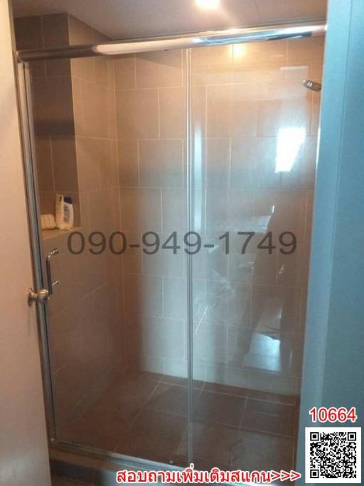 Glass-enclosed shower area in bathroom with tiled walls