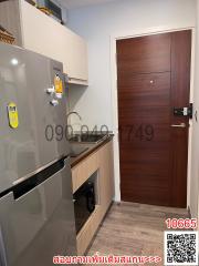 Compact modern kitchen with stainless steel refrigerator and wooden cabinets