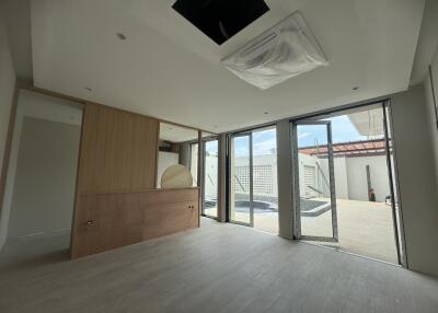 Spacious and well-lit empty living room with large sliding doors leading to an outside area