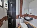 Modern bathroom with black and mosaic tiles, shower, and white fixtures