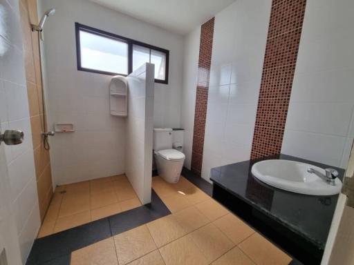 Compact bathroom with modern fixtures and tiled walls