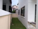 Neatly maintained side yard with green lawn between residential buildings
