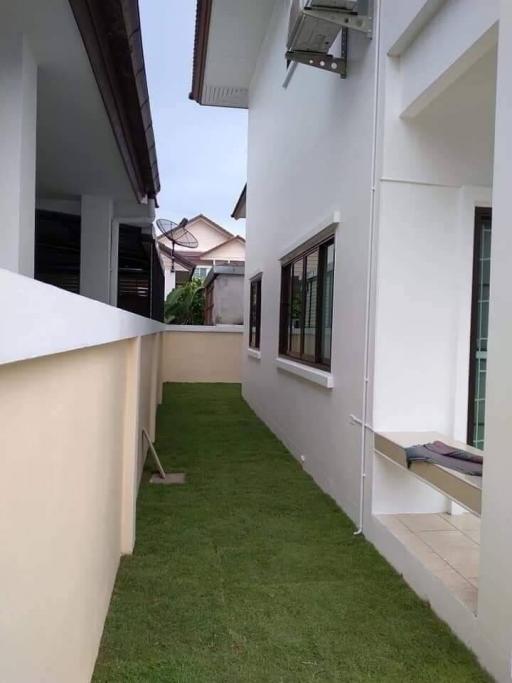 Neatly maintained side yard with green lawn between residential buildings