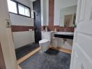 Modern spacious bathroom with black floor tiles and white fixtures