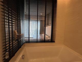 Modern bathroom interior with large bathtub and window blinds