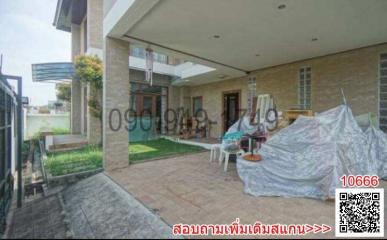 Covered patio area of a residential house with lawn and outdoor furniture