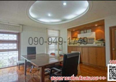 Spacious home office with circular ceiling feature, ample natural light, and a view towards the kitchen