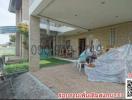 Covered patio area with belongings and a lawn at a residential property