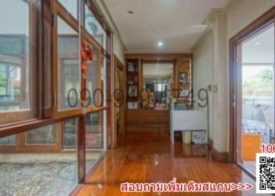 Spacious and well-lit hallway with hardwood floors and glass doors