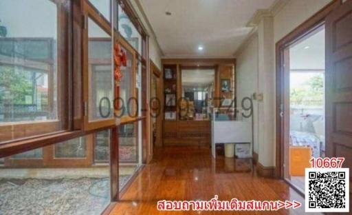 Spacious and well-lit hallway with hardwood floors and glass doors