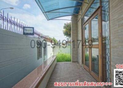 Covered walkway outside building with large windows and privacy wall