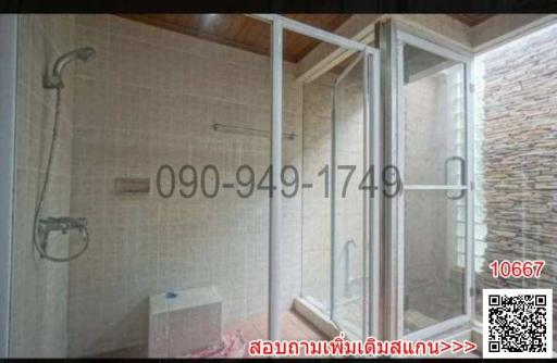 Spacious modern bathroom with glass shower enclosure and neutral tiles