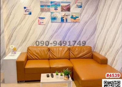 Cozy living room with a comfortable brown leather sofa and decorative wall art
